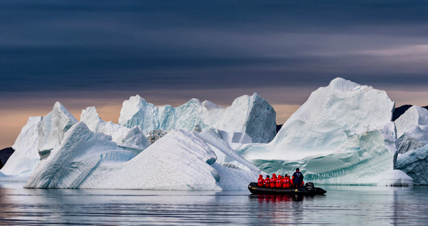 Пассажиры круизируют рядом с айсбергом в Гренландии