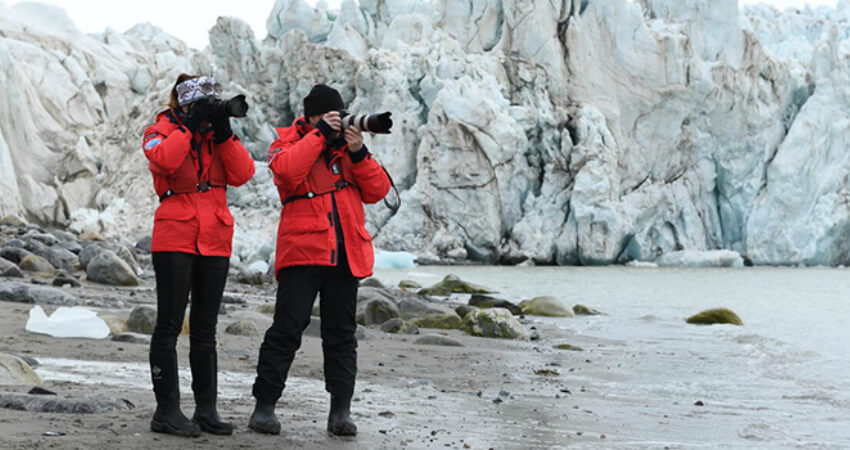 Путешественники делают фотографии в полярном экспедиционном круизе